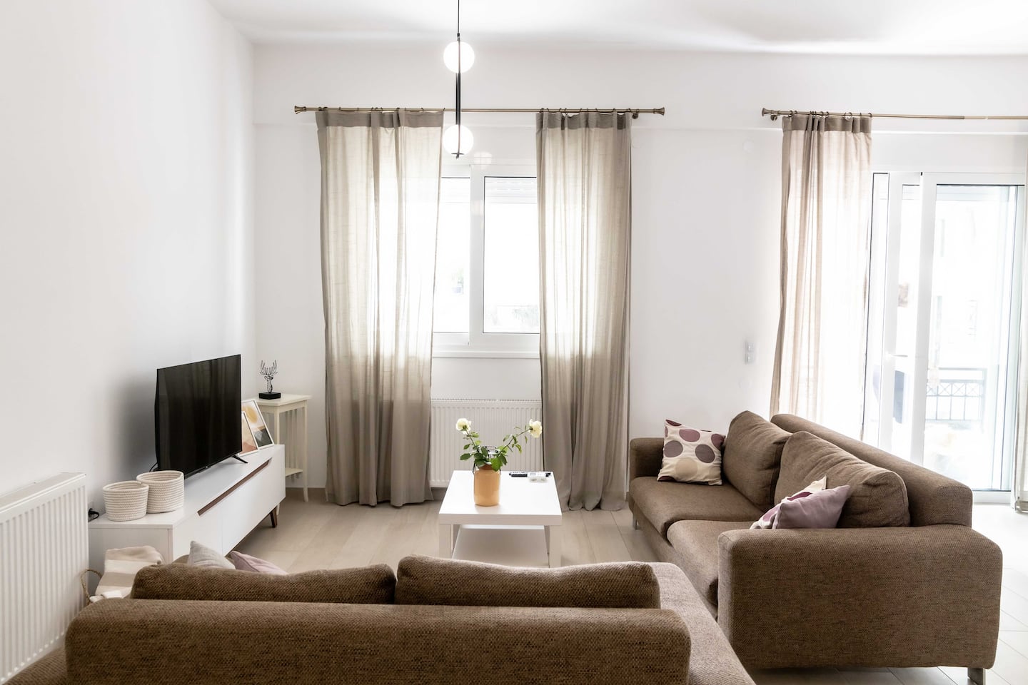 Bright, sunlit living room with large windows at Donum House in Heraklion, Crete